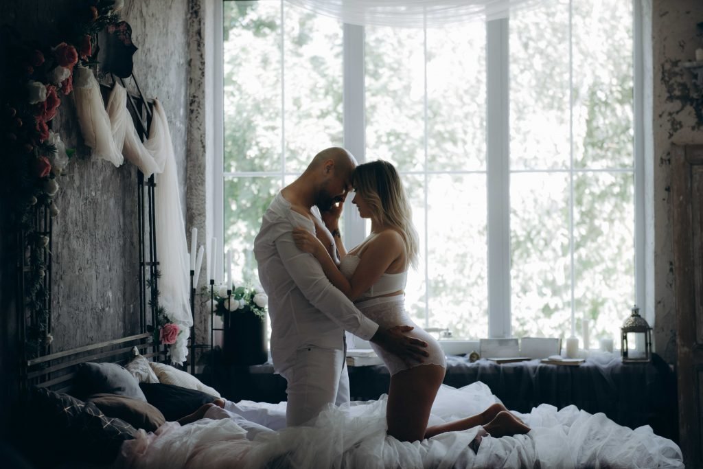 man and woman kneeling on bed beside window 1700765