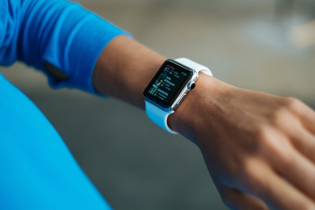 person wearing white silicone strap black smart watch 267394