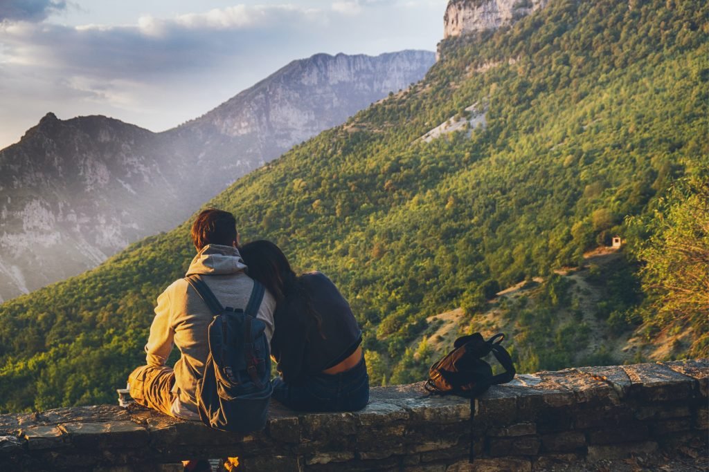 couples sitting in while facing mountain 1483024